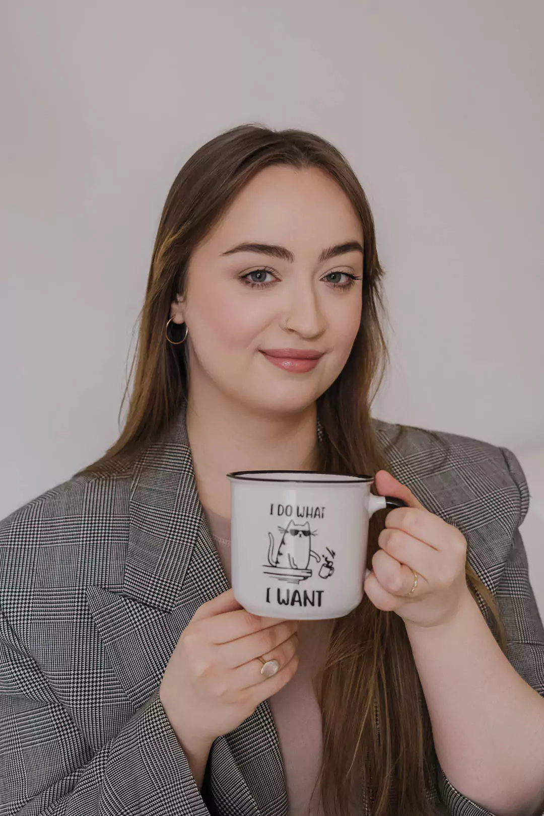 obieta z długimi włosami trzymająca kubek z napisem „I do what I want” i rysunkiem kota